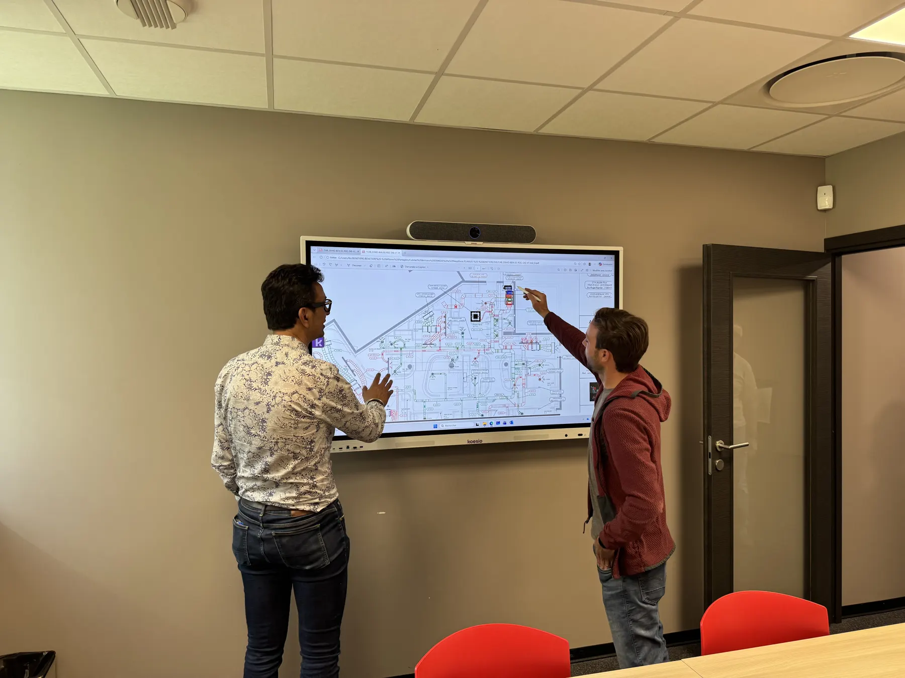 Revue de plan sur grand écran dans la salle de réunion du siège